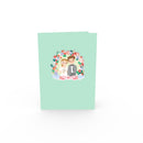 Biglietto pop-up sposi sotto un arco floreale